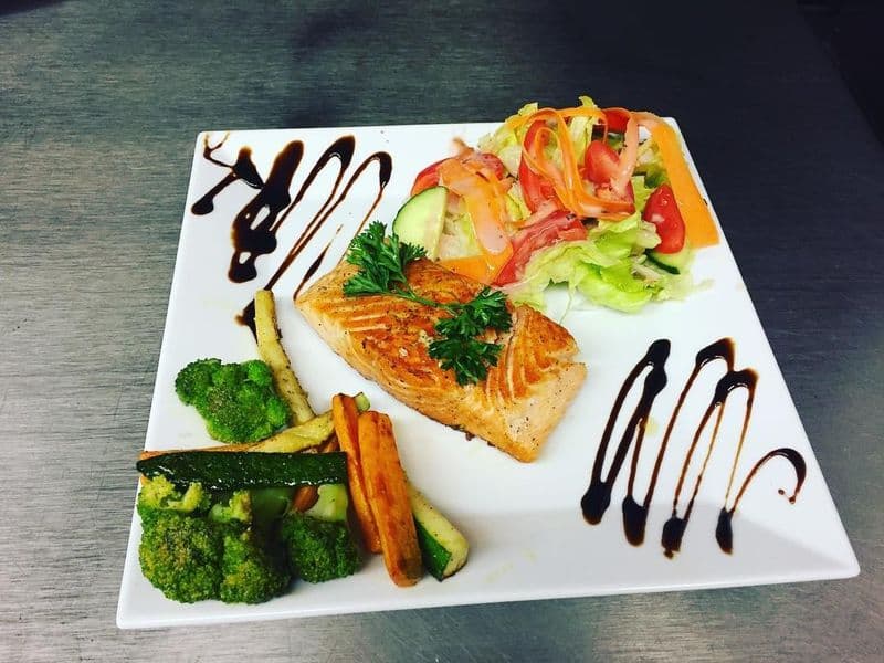 Angerichtetes Lachsfilet mit Ofengemüse und Balsamico